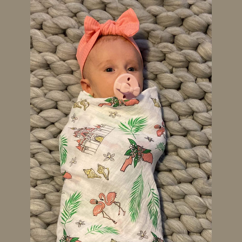 Floral-themed baby muslin swaddle blanket and burp cloth set with pink, yellow, and green flower patterns.