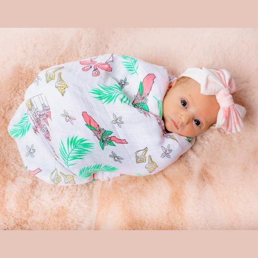 Floral muslin swaddle blanket and burp cloth set with pink, yellow, and green flowers on a white background.