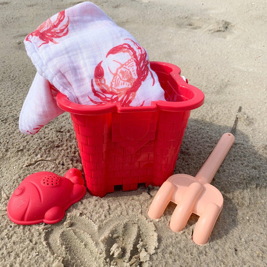Pink crab-themed baby muslin swaddle blanket and burp cloth set, neatly folded on a white background.