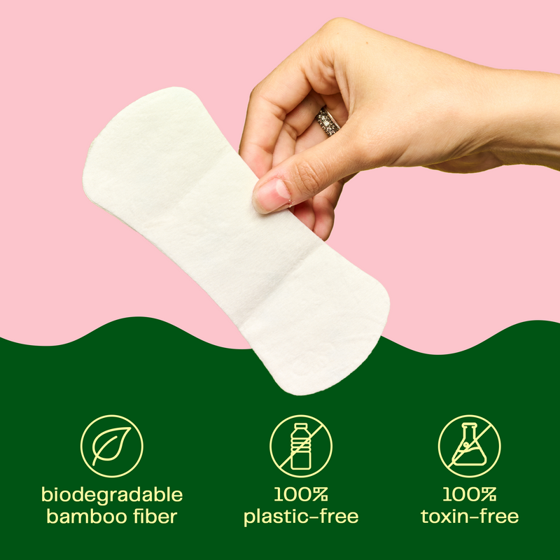 A hand holding a panty liner which is made of biodegradable bamboo fiber and is 100% plastic and toxin free. 