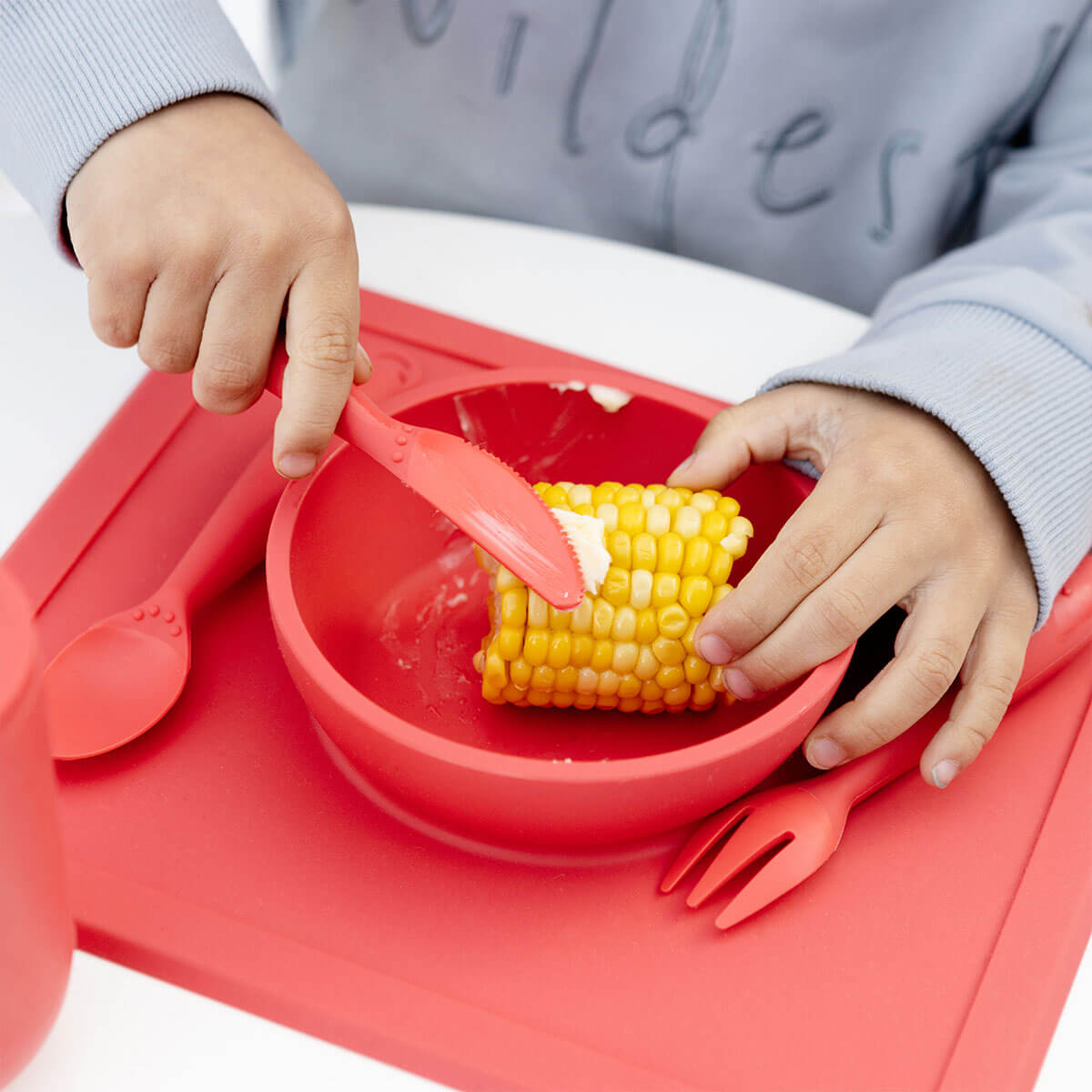 Happy Utensils in Coral by ezpz / Silicone Spoon, Fork and Knife Set for Kids #color_coral