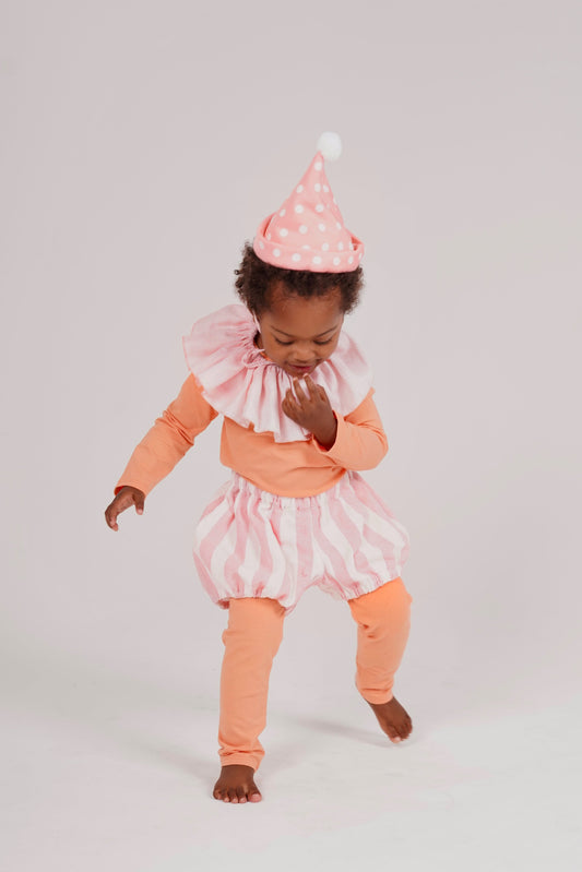 Child wearing a clown costume with pink and orange outfit and polka dot hat on a light gray background, Pink Clown Costume – Baby / Kids’ Dress Up & Pretend Play