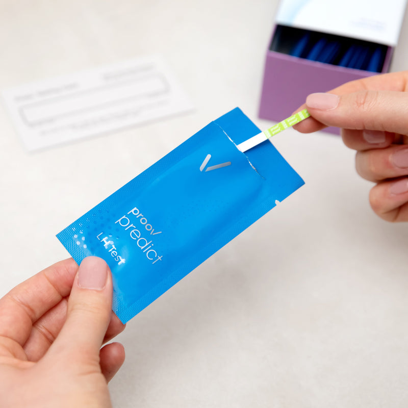 hands pulling predict test strip out of pouch