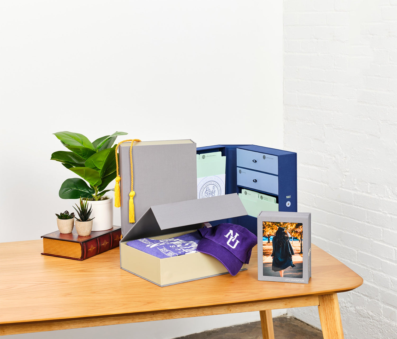 an open something blue graduate vault keepsake box, a closed slate one and a slate overflow box box on a table