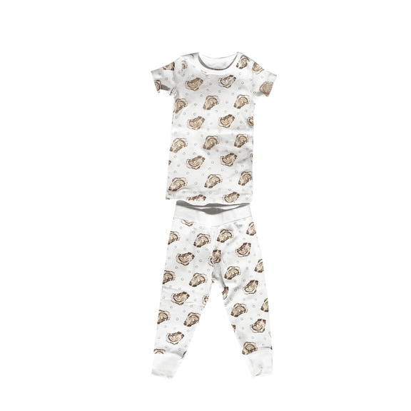 Toddler wearing "Aw Shucks" oyster-themed pajamas, smiling and holding a toy oyster, on a white background.