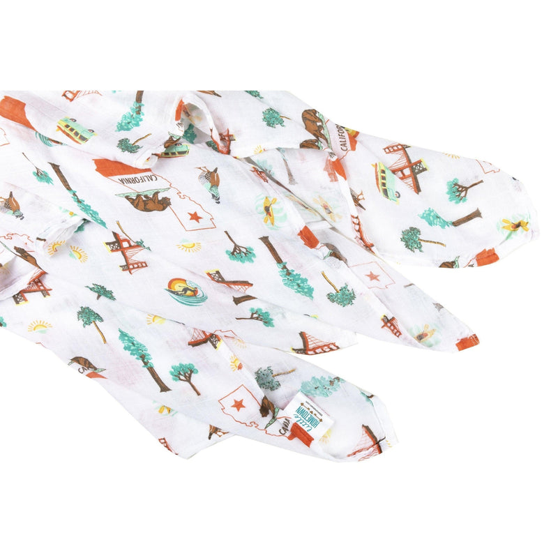 Gift set with a California Baby muslin swaddle blanket and burp cloth/bib combo, featuring a playful bear design.