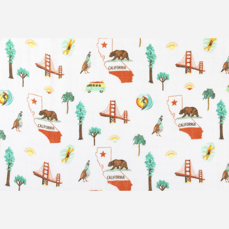 California Baby muslin swaddle blanket and burp cloth set with playful bear and tree patterns on a white background.