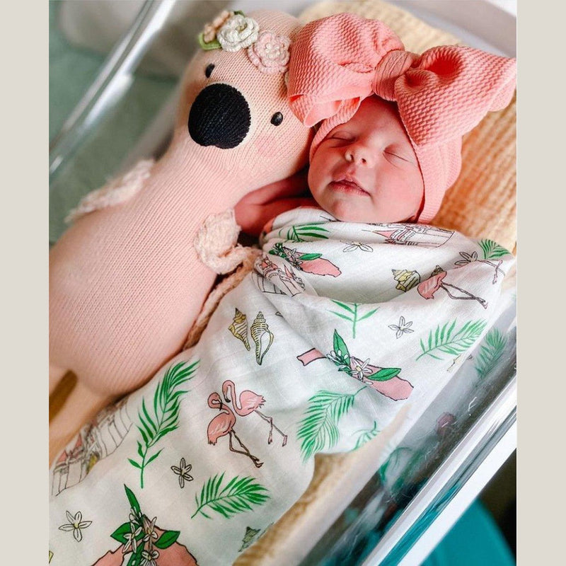 Floral-themed baby muslin swaddle blanket and burp cloth set, featuring vibrant pink and green flowers.