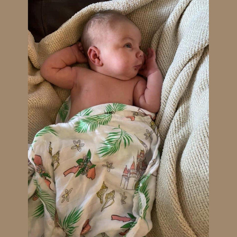 Floral-themed baby muslin swaddle blanket and burp cloth set, featuring vibrant pink and green flowers.