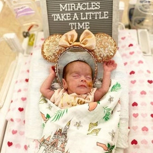 Floral-themed baby muslin swaddle blanket and burp cloth set, featuring vibrant pink and green flowers.