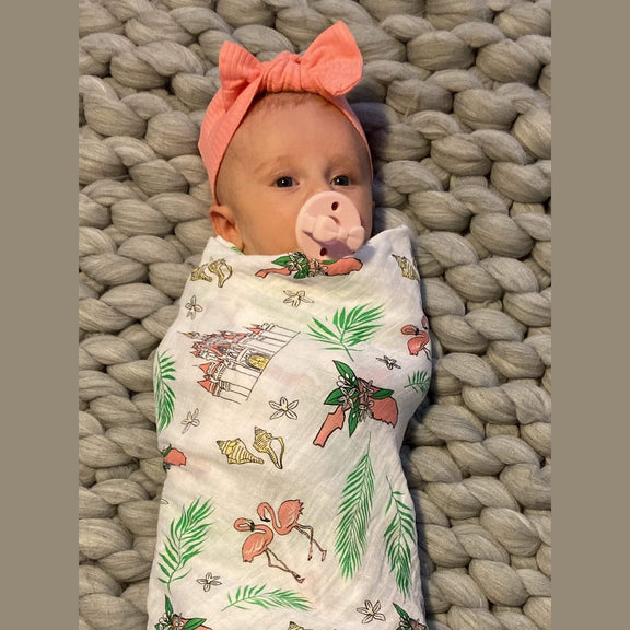 Floral-themed baby muslin swaddle blanket and burp cloth set with pink, yellow, and green flower patterns.