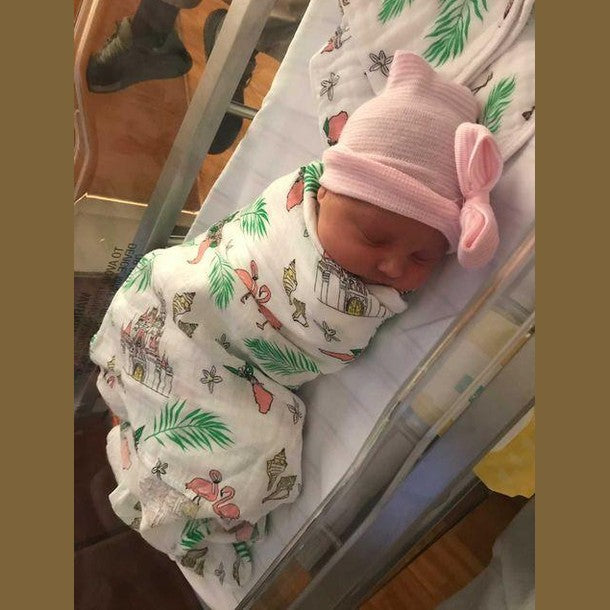 Floral baby muslin swaddle blanket and burp cloth set with pink, yellow, and green flower patterns.