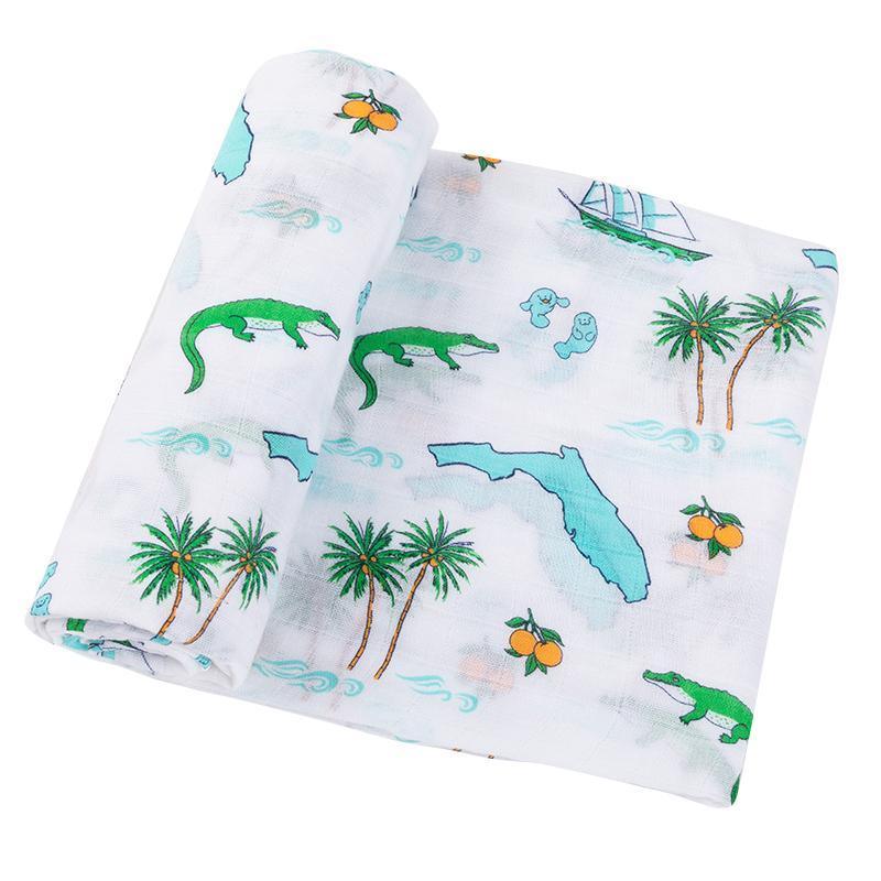Florida-themed baby gift set with muslin swaddle blanket and burp cloth, featuring orange and green citrus prints.