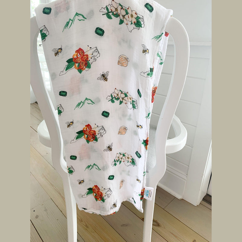 North Carolina-themed baby gift set with floral muslin swaddle blanket and matching burp cloth/bib combo.