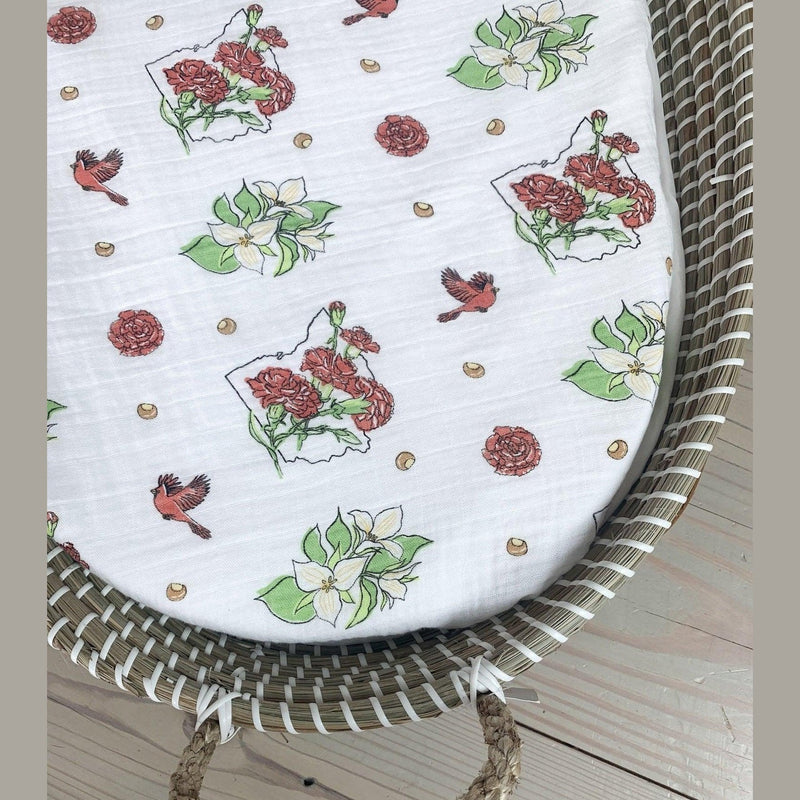 Ohio-themed baby gift set with floral muslin swaddle, receiving blanket, and burp bib, neatly arranged.