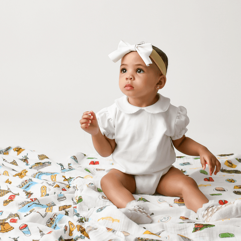 Philadelphia-themed baby gift set with muslin swaddle blanket and burp cloth, featuring iconic city landmarks.
