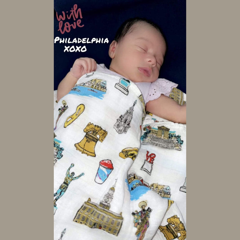 Philadelphia-themed baby muslin swaddle blanket and burp cloth set with iconic city landmarks in soft pastel colors.