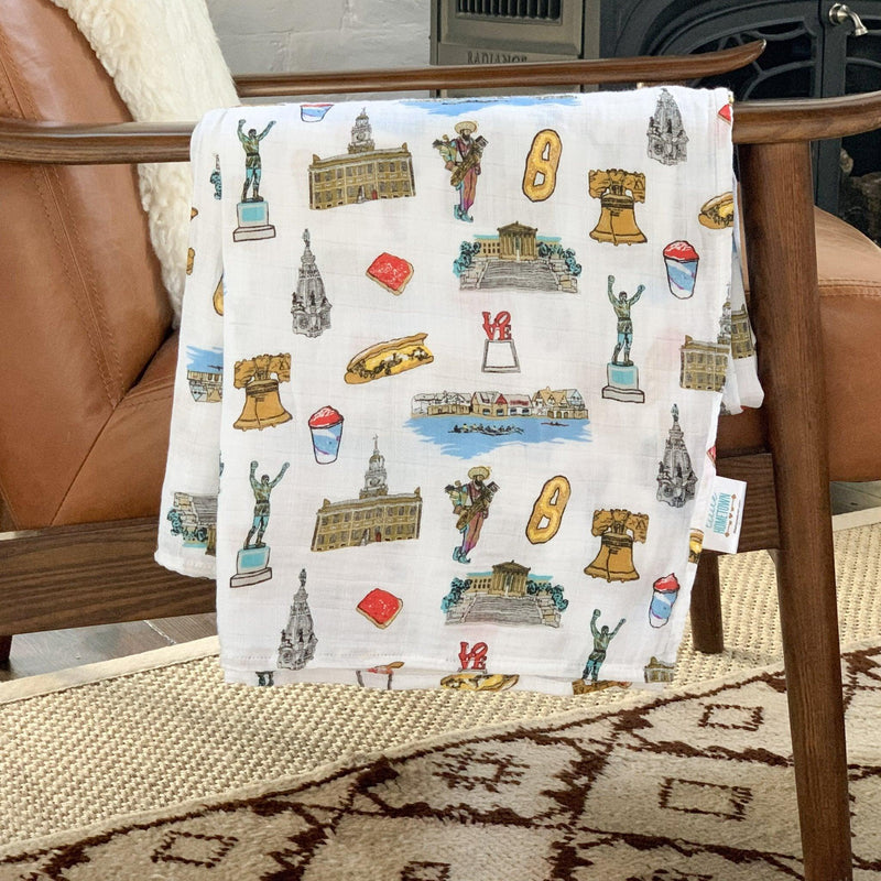 Philadelphia-themed baby gift set with muslin swaddle blanket and burp cloth, featuring iconic city landmarks.