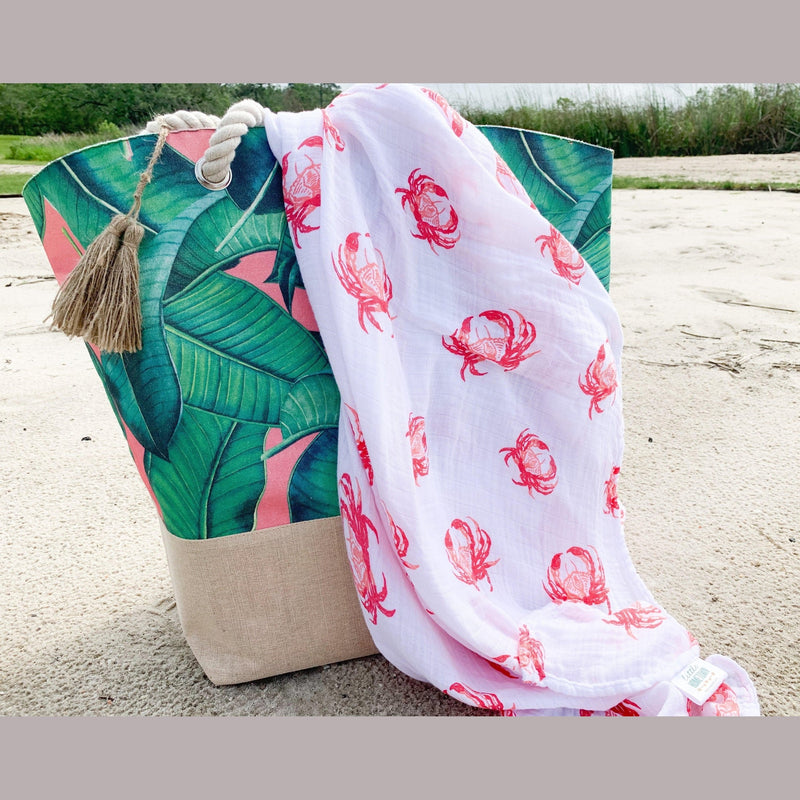 Pink crab-themed baby muslin swaddle blanket and burp cloth set, neatly folded on a white background.