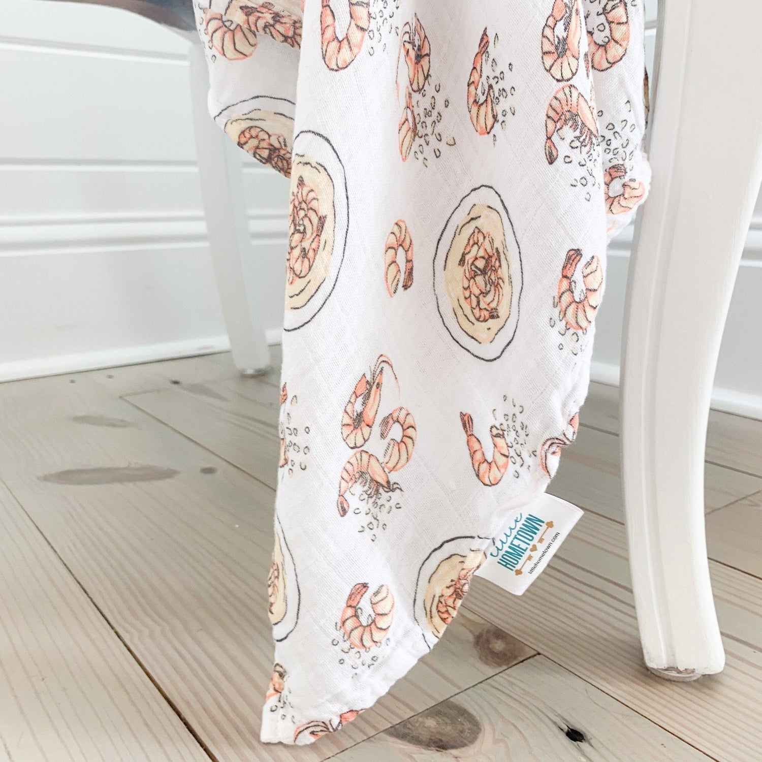 Gift set featuring a shrimp and grits-themed baby muslin swaddle blanket and burp cloth/bib combo.