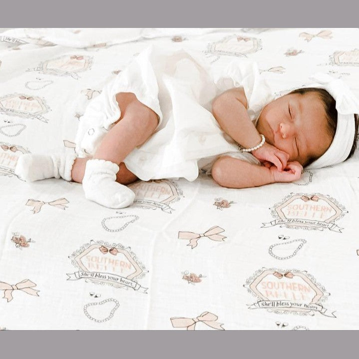 Southern Belle baby muslin swaddle blanket and burp cloth set with floral patterns, neatly folded on a white background.