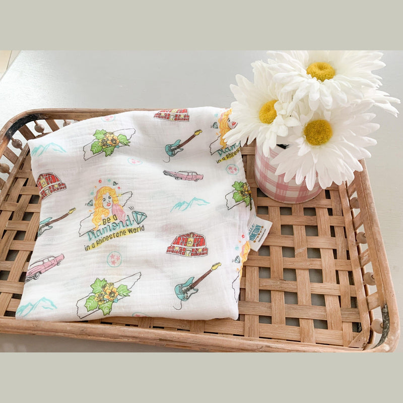 Floral muslin swaddle blanket and burp cloth set with "Tennessee Baby" text, featuring delicate pink and green flowers.