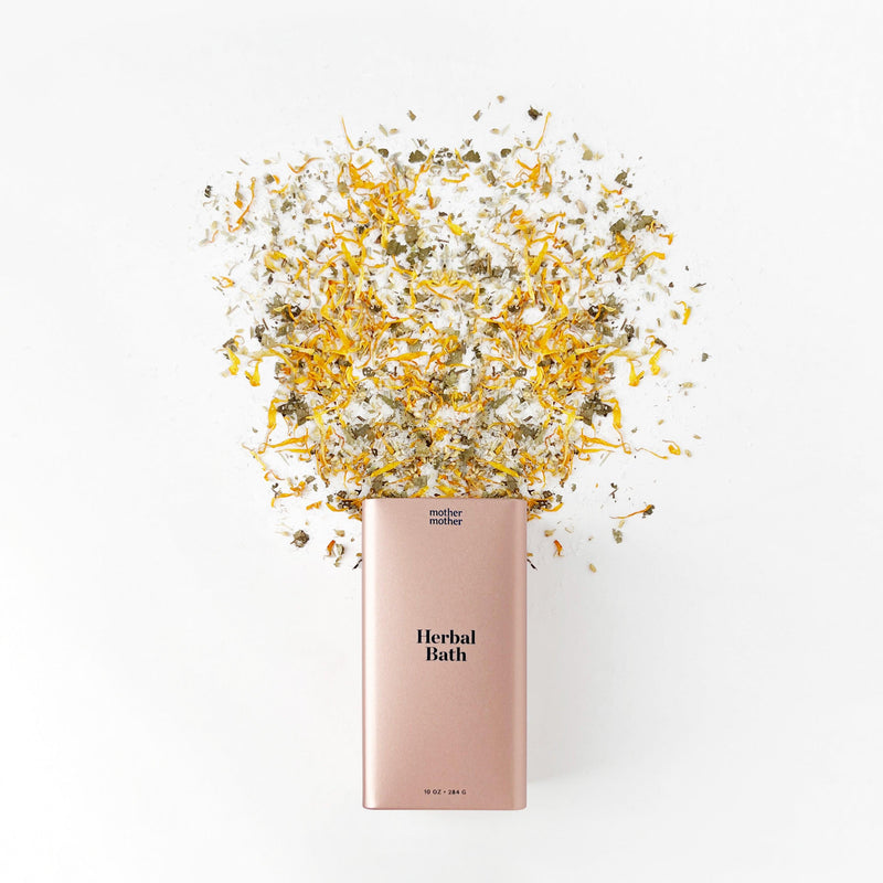 herbal bath pink tin with herbs spilling out on a white background